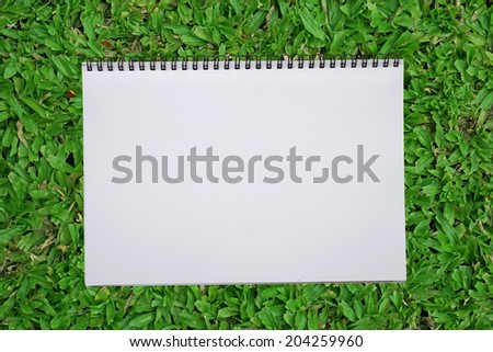 blank notebook recycle paper open two page with copy space area for multipurpose use open on green grass field
