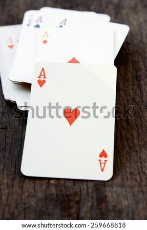 Deck of cards on wooden background (ace of heart)