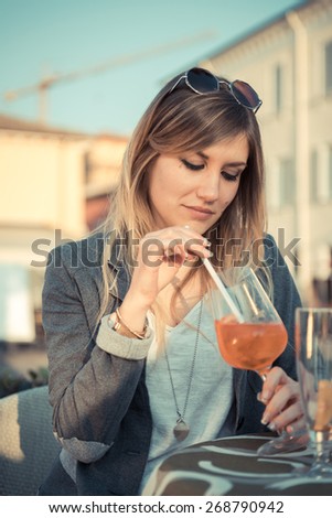 sad girl alone drinking cocktail at cafe