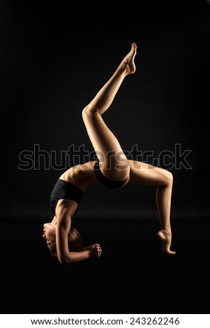 woman in yoga pose on a black background