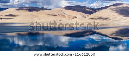 Tso Moriri (Tsomoriri) mountain lake panorama with mountains and blue sky reflections in the lake (north India)