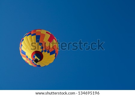 Blue, Orange, Yellow and Red Hot Air Balloon with Clear Blue Skies