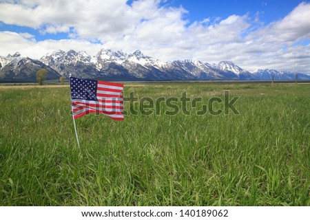 American Flag in Green Meadow Flanking the Rocky Mountains