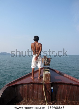 back of man stand on boat