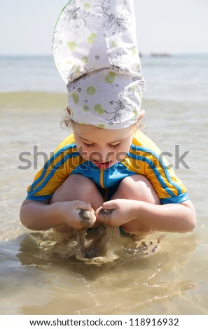 Little girl plays with sand and water