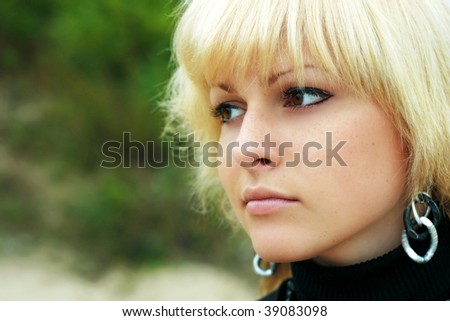 a blond girl looks in distance, nature