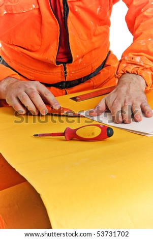 worker cuts the folded sheet of paper
