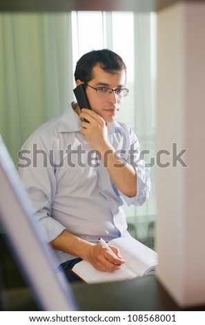 Self-employed man working at home. Talking on phone
