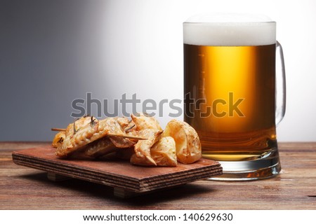 One glass of beer and grilled chicken wings
