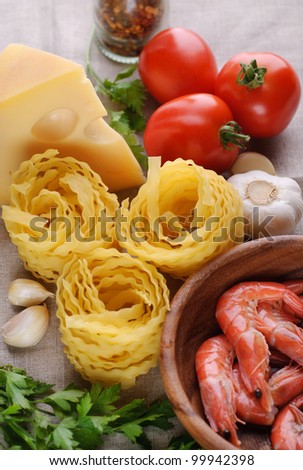 Raw pasta, shrimps, tomato, cheese and garlic. Ingridient for cooking pasta with shrimps and tomato