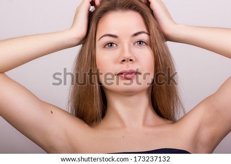 Studio portrait of a beautiful young woman with blond long hair without makeup