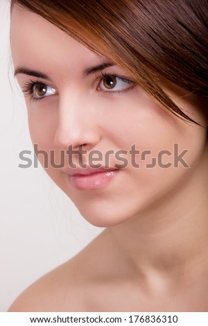 Natural portrait of a beautiful young woman with brown straight hair and clean skin without makeup