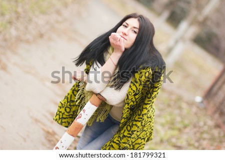 Outdoor portrait of young pretty beautiful woman in cold spring weather in park. Sensual brunette posing and having fun