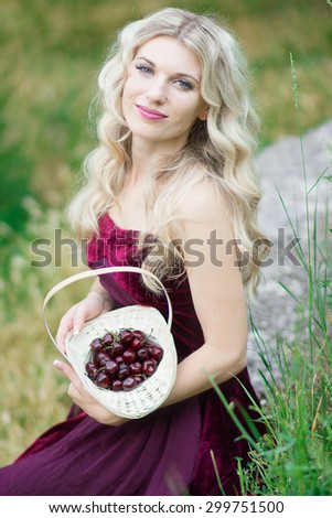 Portrait of beautiful young woman with berries in basket