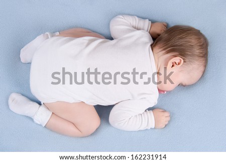 Baby sleeps on soft blue blanket. Top view