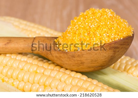 corn grits in old wooden spoon and cobs