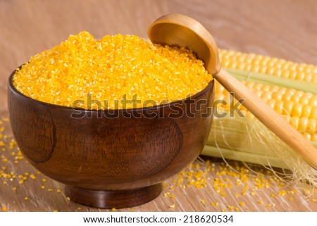 corn grits in a wooden bowl and cobs