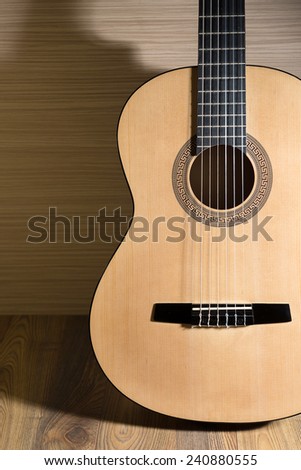 acoustic six-string guitar on the background of wooden panels