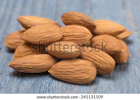 peeled almond nuts on a wooden background