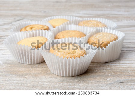 Butter cookies in a paper packing on a wooden table