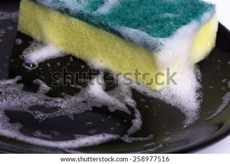 washing dishes with a sponge and dishwashing liquid