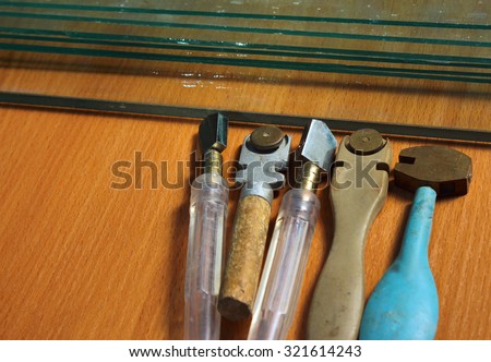 Old glass cutters and glass sheets on wooden background