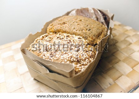 three types of bread, bread with caraway seeds, rye bread, bread with spices in a package with a bow on a wicker table
