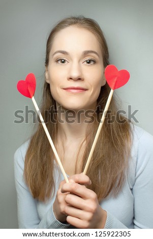 he cute girl with two hearts - hearts in the hands of a grey background
