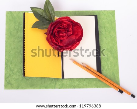 Notebook with flower and pencils