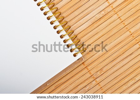 Notebook on natural bamboo textured background.