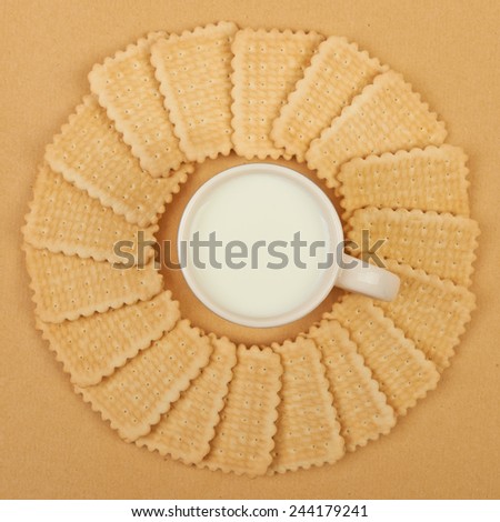 Wafer biscuits on beige with a cup of milk, background.