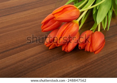 Red tulip flowers on the table, background