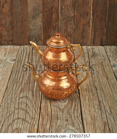 Copper kettle on the wooden table background