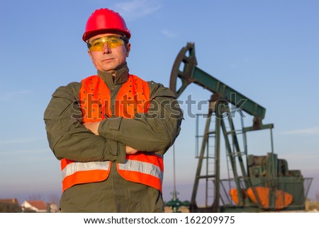 Oil Industry Pump jack with one oil worker.