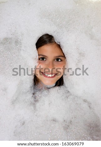 beautiful little girl taking a bath in the foam,best focus on the eyes and face, as well as the foam around the child,