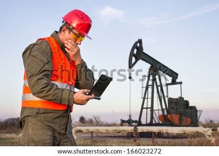 man on the oil rig holds laptop and thinking,best focus on the man, background blurred