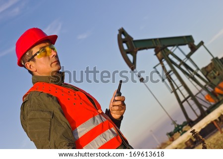 worker on an oil pump keeps the radio station and looking up,best focus on workers pumped soft focus