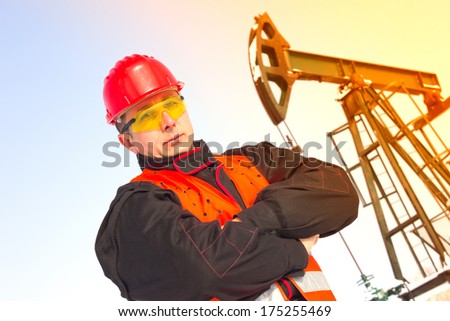 Oil Industry Pump jack with one oil worker,best focus helmet and vest, soft focus pump,lens flare, flaring