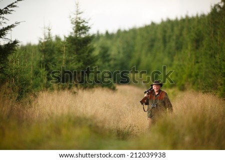 hunter with his rifle in spring forest, hunter holding a rifle and waiting for prey, hunter shooting, on the walk in forest