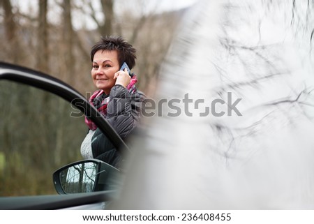 Female Driver Making Phone Calls After Traffic Accident. Woman dialing her phone after car breakdown problem. Mechanic crash