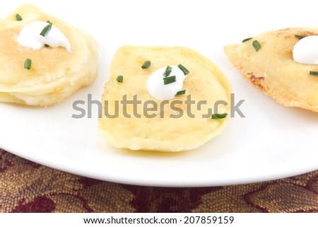Delicious authentic Polish pierogies with chives and sour cream