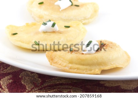 Delicious authentic Polish pierogies with chives and sour cream
