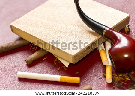 Pipe, tobacco, cigarettes, cigars, smoking, etc. on red leather background