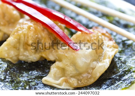 Fried Japanese dumplings on crispy roasted seaweed and red pepper garnish