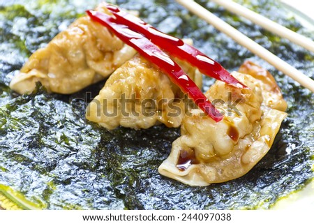 Fried Japanese dumplings on crispy roasted seaweed and red pepper garnish