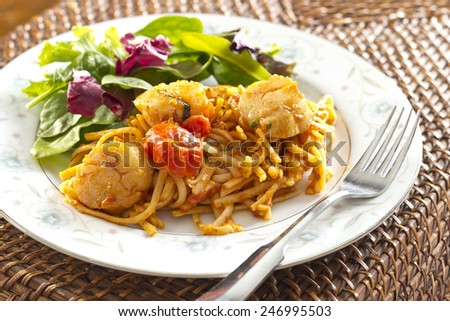 Fresh scallops with linguine pasta and tomato sauce with a side salad