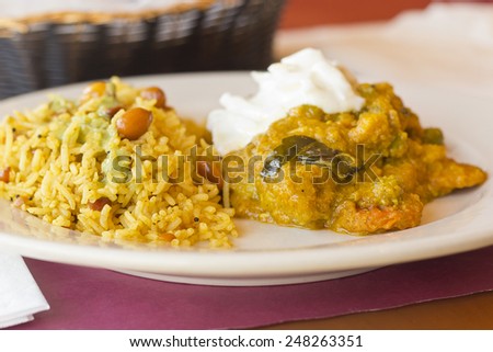 Authentic Indian vegetable Korma topped with yogurt sauce with a side of tamarind basmati rice and peanuts