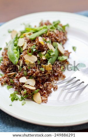 Healthy nutty red quinoa salad with sugar snap peas sliced toasted almonds and chopped parsley