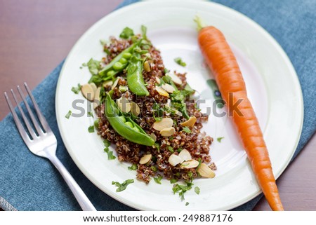 Healthy nutty red quinoa salad with sugar snap peas sliced toasted almonds and chopped parsley
