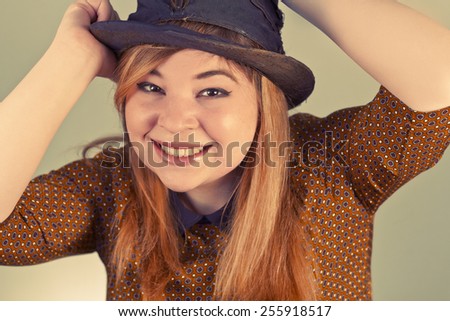 Tramp girl wears old top hat in vintage photo style